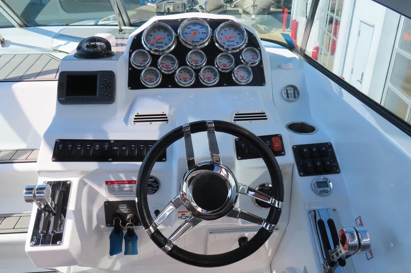 Slide: The Image of 2008 Baja 335 Performance boat dashboard with gauges, steering wheel, and controls. - 11