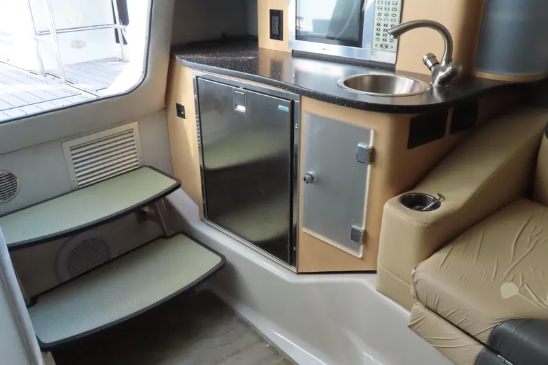 Slide: The Image of 2008 Baja 335 Performance boat interior with kitchenette, sink, and seating area. - 16