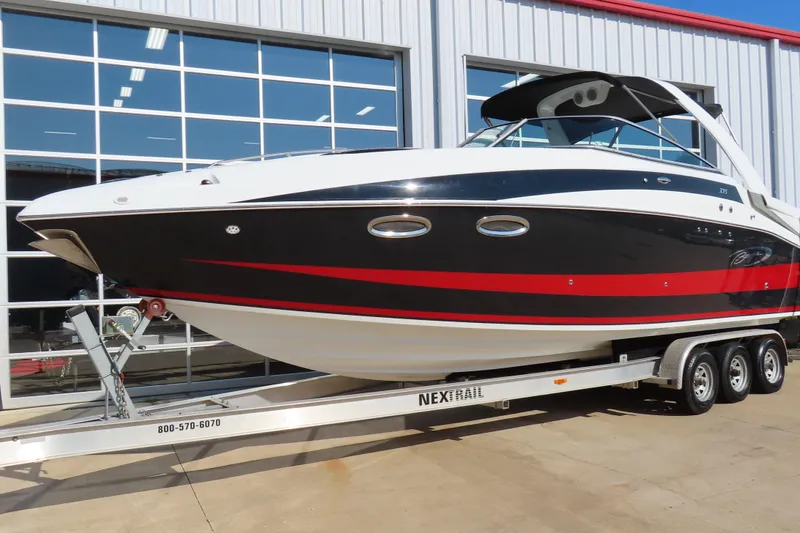 Slide: The Image of 2008 Baja 335 Performance boat on trailer, black and red design, parked outside a building. - 2