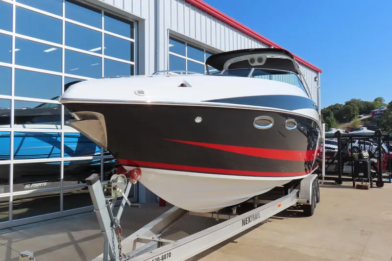 Slide: The Image of 2008 Baja 335 Performance boat on trailer, parked outside a modern building. - 3