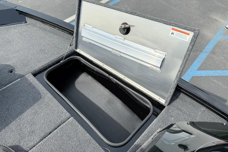Slide: The Image of Open storage compartment on 2025 Crestliner XF 179 boat, featuring carpeted interior. - 5