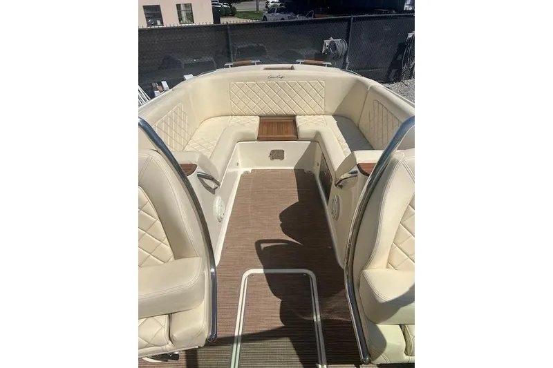 Slide: The Image of 2024 Chris-Craft Launch 27 boat interior with beige seating and wooden flooring. - 6