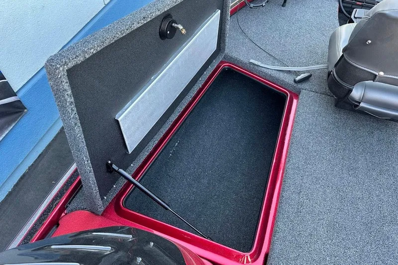 Slide: The Image of Open storage compartment in 2024 Nitro Z17 boat, featuring carpeted interior and hydraulic lift. - 22