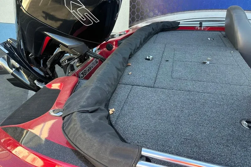 Slide: The Image of 2024 Nitro Z17 boat deck with motor, featuring red accents and carpeted surface. - 29