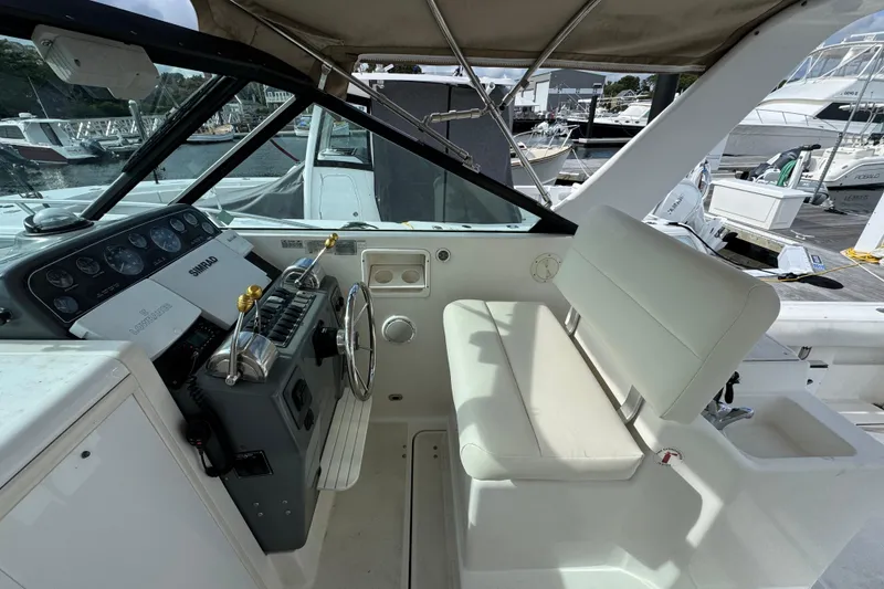 Slide: The Image of 1999 Tiara Yachts 2900 Open helm with steering wheel and control panel, docked at marina. - 14