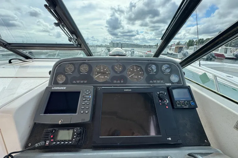 Slide: The Image of 1999 Tiara Yachts 2900 Open dashboard with navigation and control instruments, docked under cloudy skies. - 16