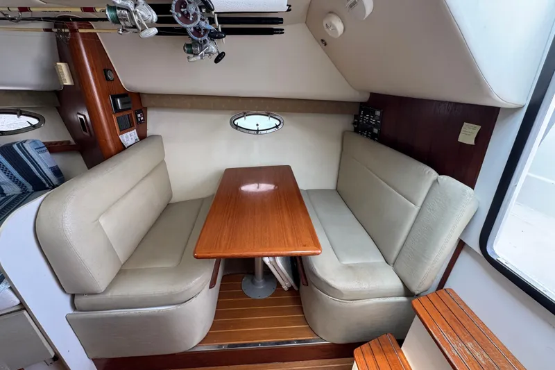 Slide: The Image of 1999 Tiara Yachts 2900 Open interior with dining area and fishing rods. - 26