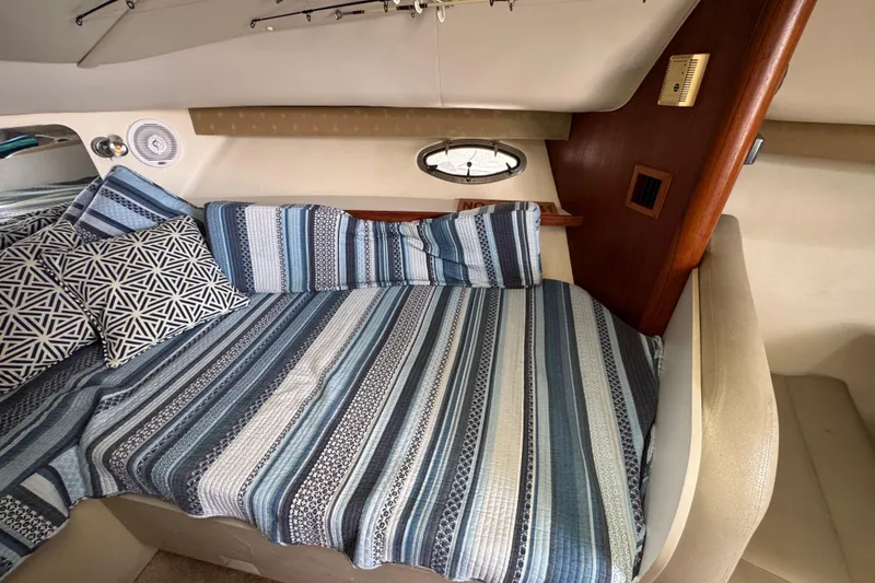 Slide: The Image of 1999 Tiara Yachts 2900 Open cabin with striped bedding and geometric pillows. - 31