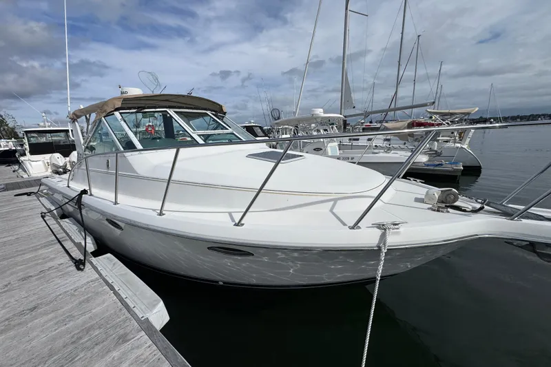 Slide: The Image of 1999 Tiara Yachts 2900 Open docked at marina, showcasing sleek design and spacious deck. - 4