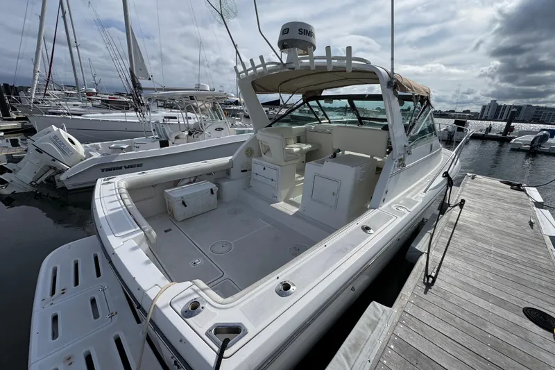 Slide: The Image of 1999 Tiara Yachts 2900 Open docked at marina, showcasing spacious deck and seating. - 6