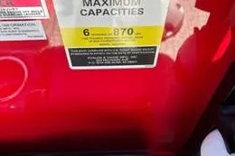 Slide: The Image of 2026 Avalon VENTURE CRUISE maximum capacity label on red surface. - 2