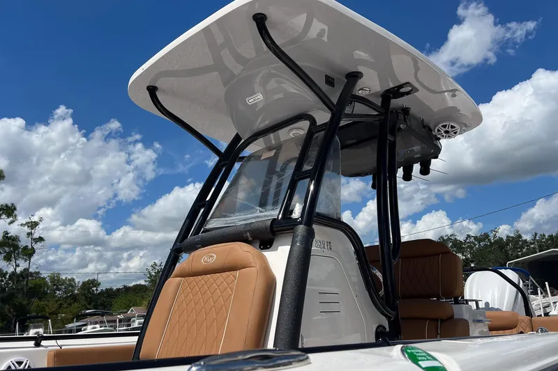 Slide: The Image of 2026 Key West 239 FS boat with tan seating and T-top under blue sky. - 27
