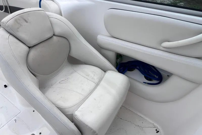 Slide: The Image of 2004 Chaparral Sunesta 254 boat interior with white seating and storage compartment. - 11