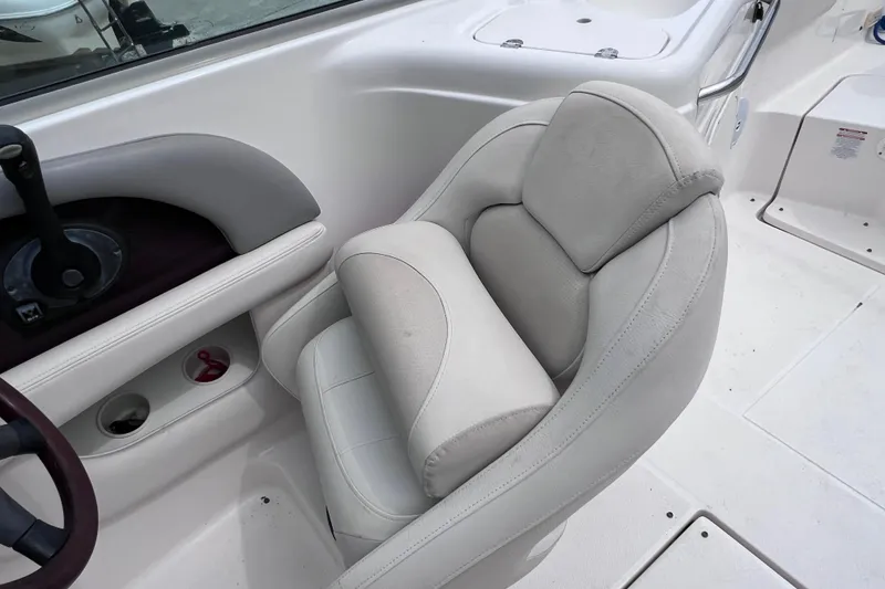 Slide: The Image of 2004 Chaparral Sunesta 254 boat interior with white cushioned seating. - 12