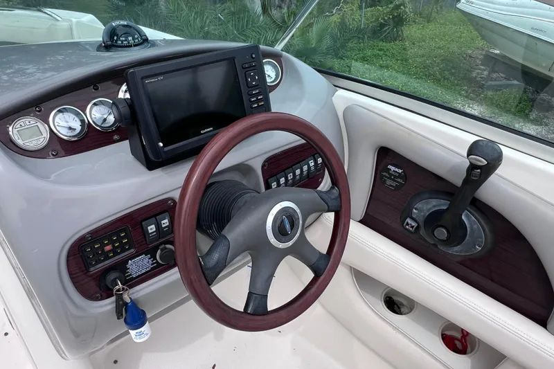 Slide: The Image of 2004 Chaparral Sunesta 254 boat dashboard with steering wheel and navigation controls. - 13