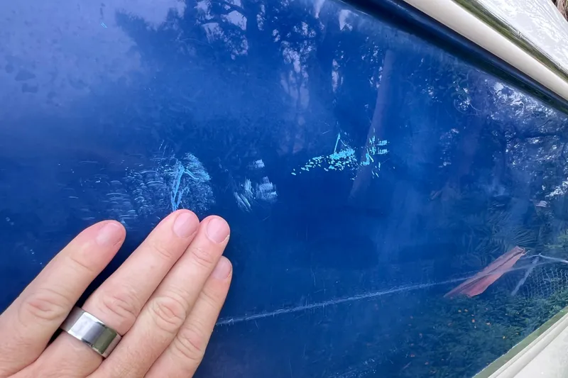 Slide: The Image of Hand touching blue surface of 2004 Chaparral Sunesta 254 boat. - 4