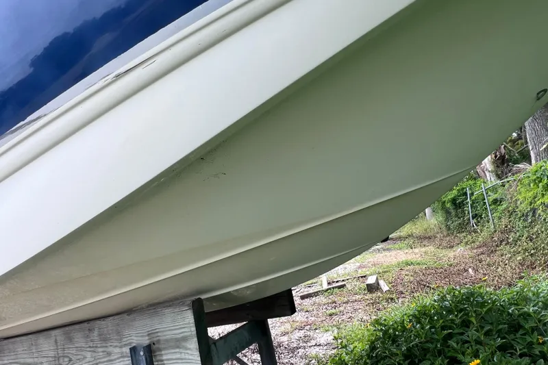 Slide: The Image of 2004 Chaparral Sunesta 254 boat hull on a stand, surrounded by greenery. - 5