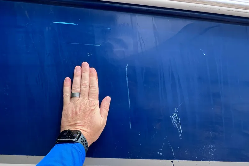 Slide: The Image of Hand touching blue surface of 2004 Chaparral Sunesta 254 boat. - 6