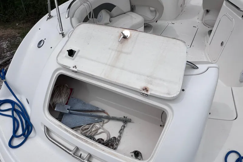 Slide: The Image of 2004 Chaparral Sunesta 254 boat with open storage compartment, anchor, and ropes visible. - 8