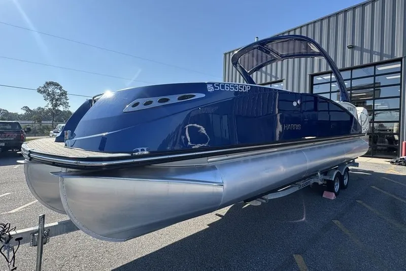 Slide: The Image of 2021 Harris Crowne SL 270 Twin Engine pontoon boat on trailer, parked outdoors. - 3