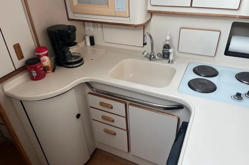 Slide: The Image of Compact kitchen in a 1996 Sea Ray 370 Sedan Bridge yacht with stove, sink, and coffee maker. - 11
