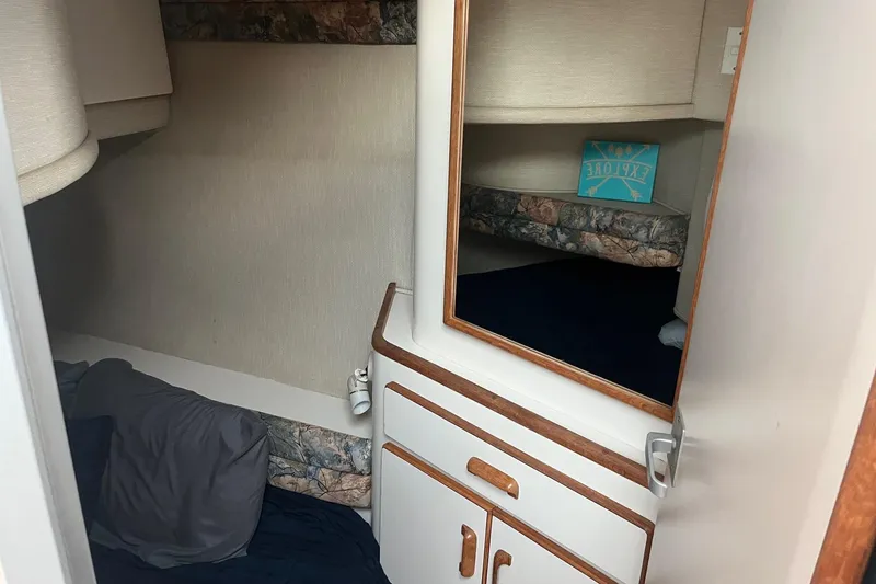 Slide: The Image of Cozy cabin interior of 1996 Sea Ray 370 Sedan Bridge with mirror and bedding. - 8
