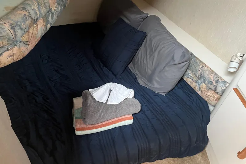 Slide: The Image of Cozy cabin interior of 1996 Sea Ray 370 Sedan Bridge with neatly arranged bedding. - 9