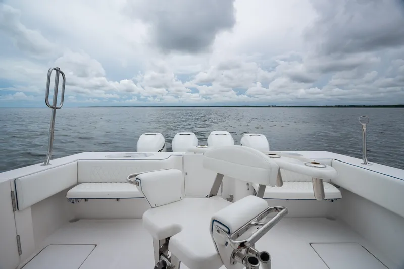 Slide: The Image of 2016 SeaHunter 45 boat interior with white seating, overlooking calm ocean and cloudy sky. - 20