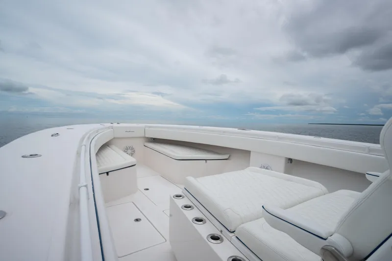 Slide: The Image of 2016 SeaHunter 45 boat interior with white seating, open sea view, and cloudy sky. - 38