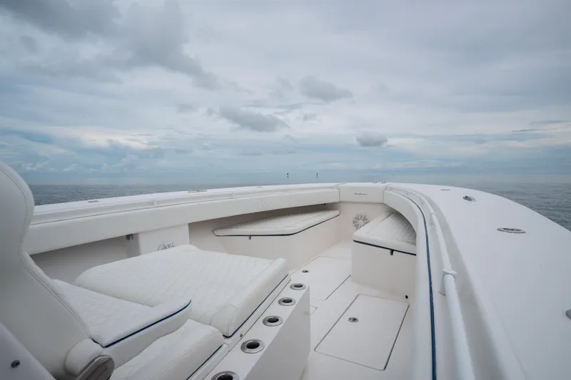 Slide: The Image of 2016 SeaHunter 45 boat interior with white seating, open ocean view, and cloudy sky. - 39