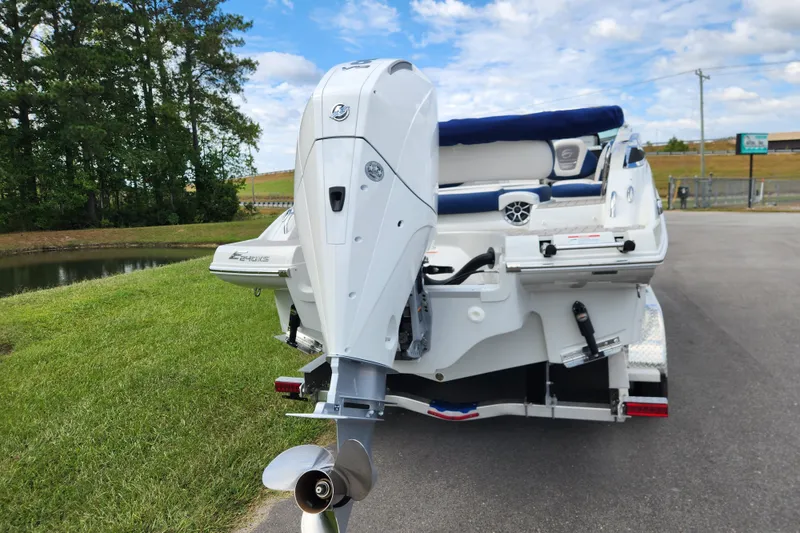 Slide: The Image of 2024 Crownline Eclipse E240 XS boat with outboard motor, parked near a pond. - 3