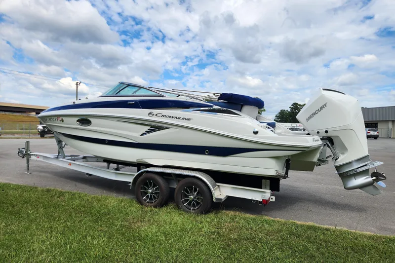 Slide: The Image of 2024 Crownline Eclipse E240 XS boat on trailer, parked outdoors under cloudy sky. - 5