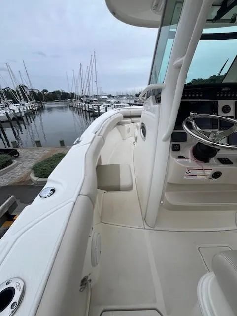 Slide: The Image of 2020 Boston Whaler 280 Outrage boat docked at marina, showcasing sleek design and helm. - 17