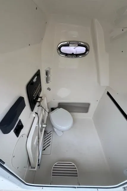 Slide: The Image of Interior of 2020 Boston Whaler 280 Outrage boat bathroom with toilet and window. - 25