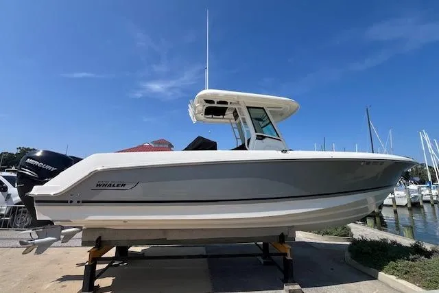 Slide: The Image of 2020 Boston Whaler 280 Outrage boat docked at a marina under clear blue skies. - 5