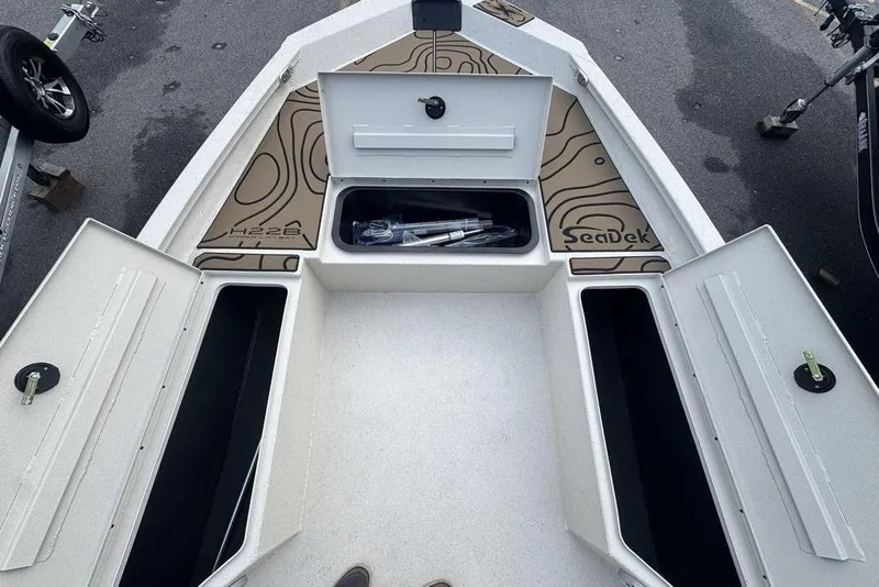 Slide: The Image of 2026 Xpress H22B Bay boat with open storage compartments and SeaDek flooring. - 12