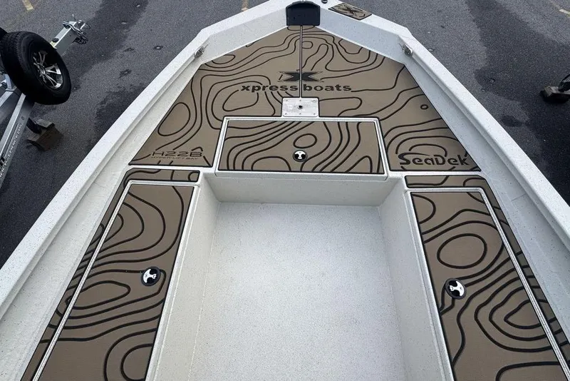 Slide: The Image of 2026 Xpress H22B Bay boat deck with SeaDek flooring, featuring contour patterns. - 13