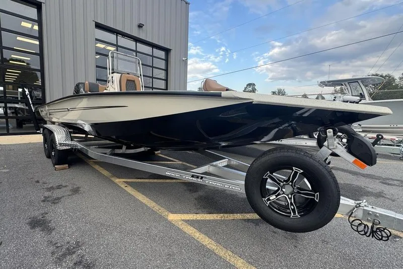 Slide: The Image of 2026 Xpress H22B Bay boat on trailer outside a building, under a cloudy sky. - 2