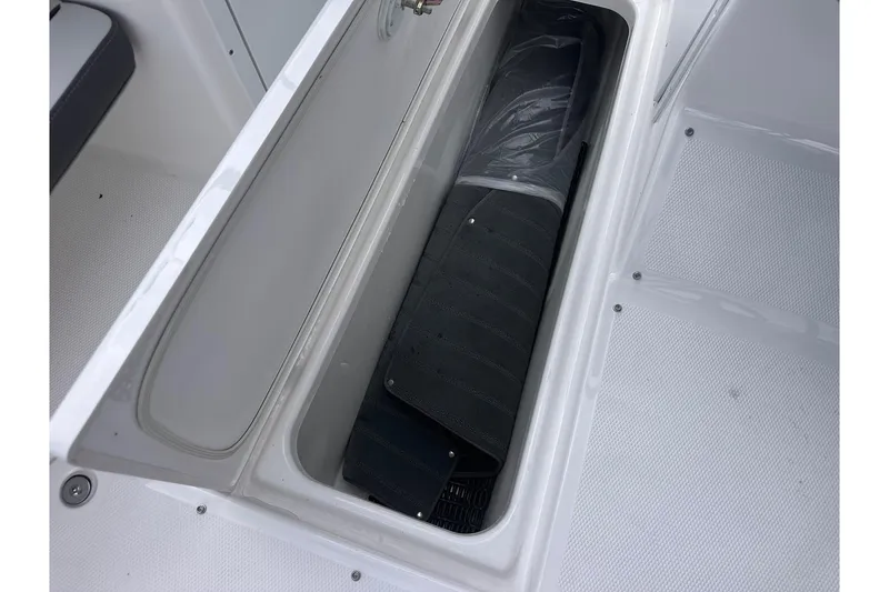 Slide: The Image of 2025 Yamaha AR190 boat storage compartment with black mat inside. - 16