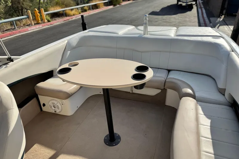 Slide: The Image of 2002 MasterCraft MariStar 230 VRS boat interior with seating and table, featuring cup holders. - 13
