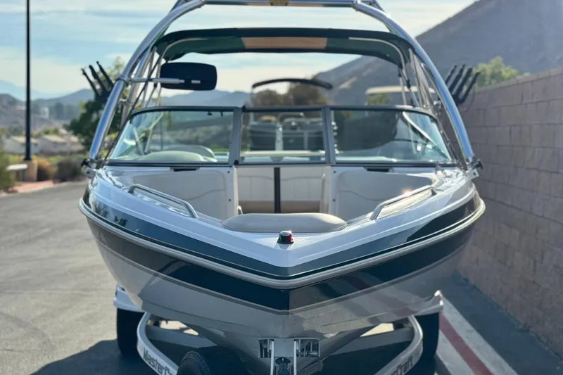 Slide: The Image of 2002 MasterCraft MariStar 230 VRS boat on trailer, parked outdoors with scenic mountain backdrop. - 2