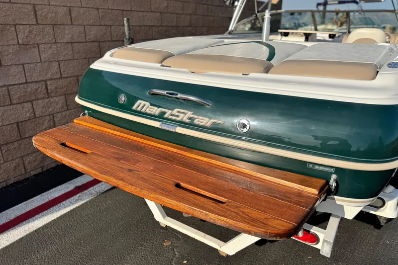 Slide: The Image of 2002 MasterCraft MariStar 230 VRS boat with wooden swim platform, parked on trailer. - 6