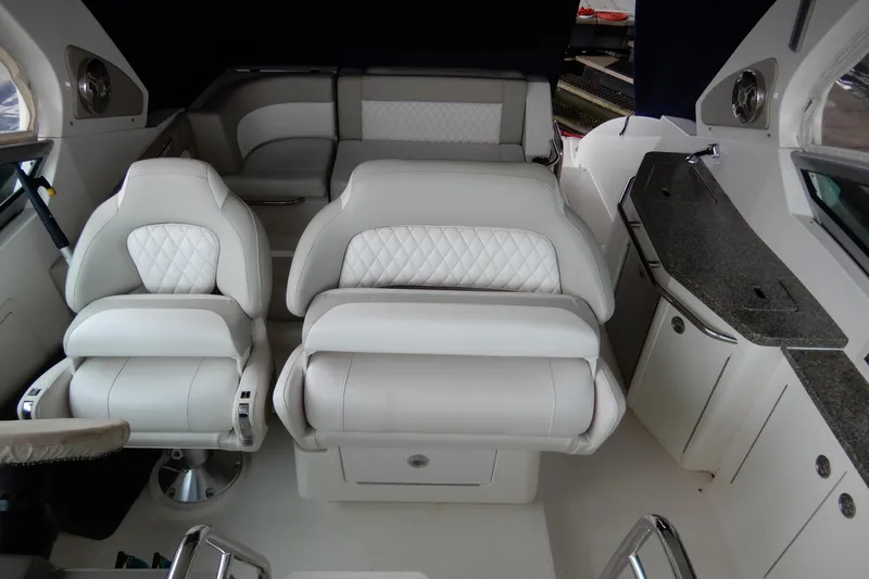 Slide: The Image of Interior of 2016 Chaparral 310 Signature boat with luxurious white seating and sleek design. - 10