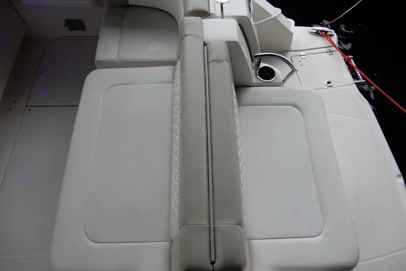 Slide: The Image of 2016 Chaparral 310 Signature boat interior with beige seating and cup holder. - 13