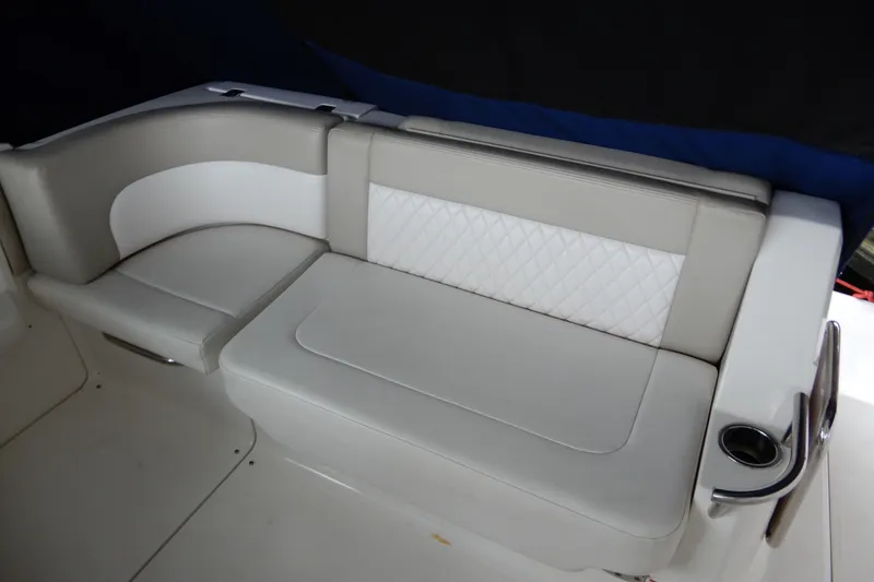 Slide: The Image of 2016 Chaparral 310 Signature boat interior seating with white and gray upholstery. - 16