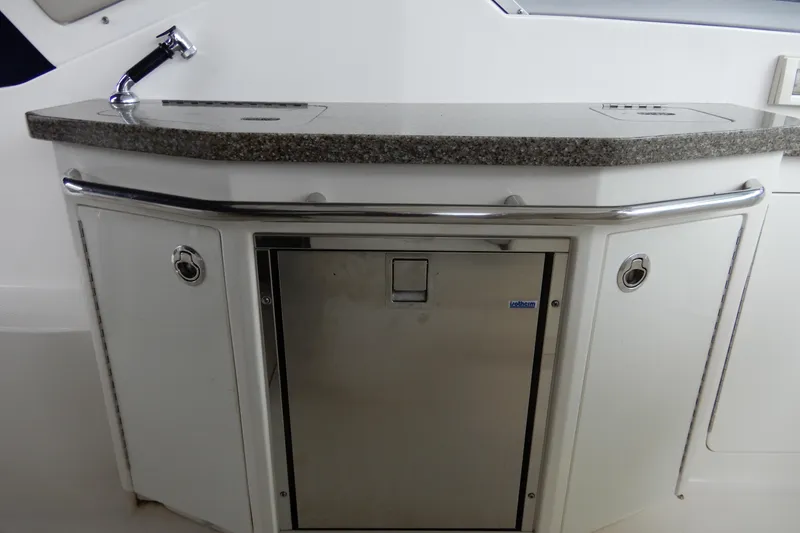 Slide: The Image of 2016 Chaparral 310 Signature boat kitchenette with sink and mini fridge. - 20