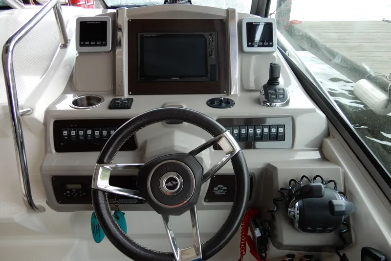 Slide: The Image of 2016 Chaparral 310 Signature boat dashboard with steering wheel and control panel. - 24