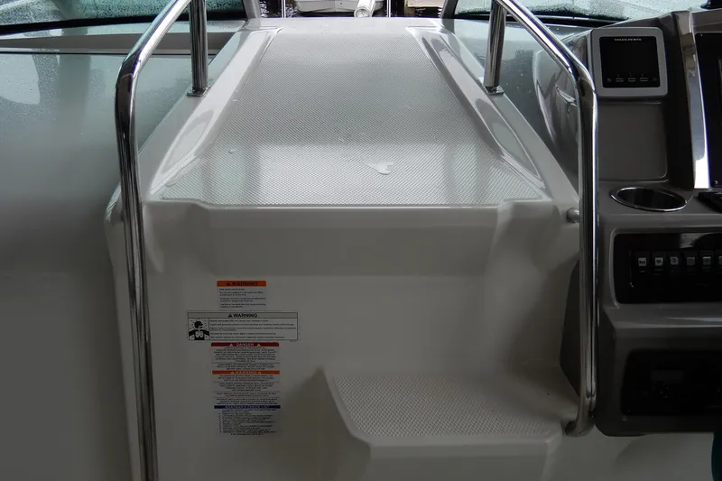 Slide: The Image of 2016 Chaparral 310 Signature boat dashboard with control panel and safety warnings. - 29