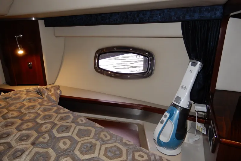Slide: The Image of Interior of 2016 Chaparral 310 Signature boat cabin with bed and porthole. - 33