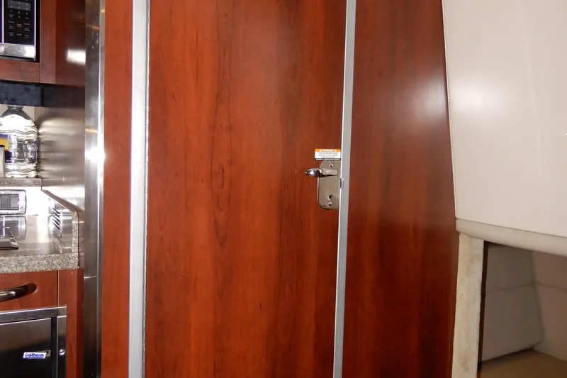 Slide: The Image of Interior of 2016 Chaparral 310 Signature boat, featuring wood cabinetry and modern appliances. - 36